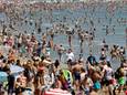 Strandgangers genieten van een zonnige dag op het Malvarrosa-strand in Valencia.