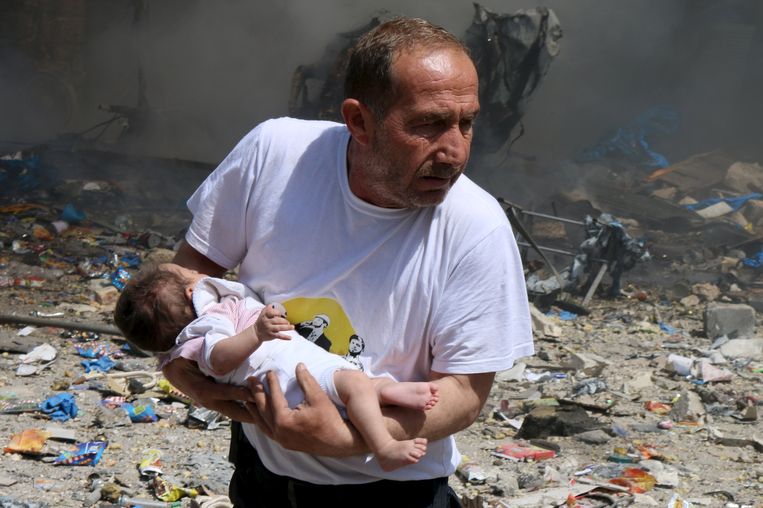 Een man met een baby die het bombardement op Aleppo overleefde. Activisten zeggen dat het Syrische regeringsleger de stad bombardeerde. Beeld reuters