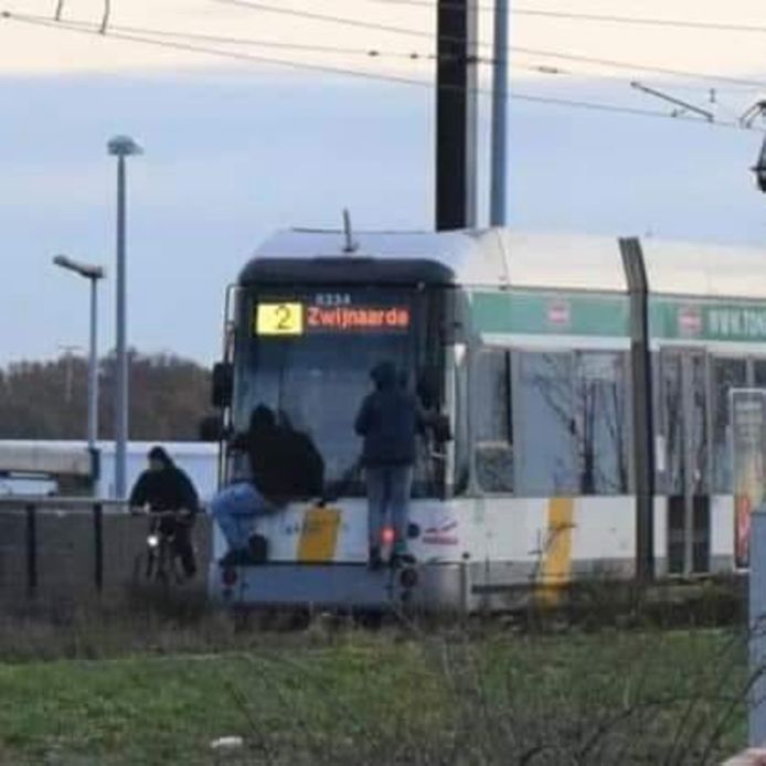 Twee jongeren die meesurfen met de tram