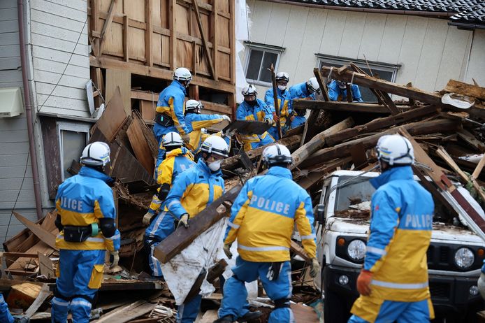 Politie zoeken onder het puin van een gebouw in de stad Wajima naar overlevenden.
