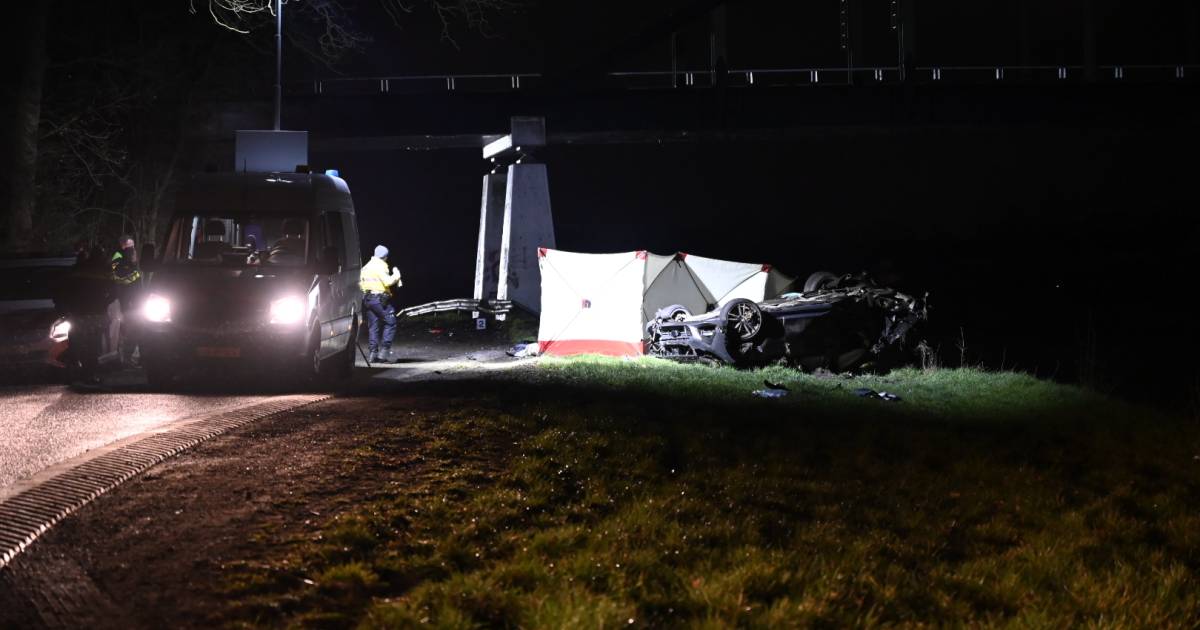 Zwaar ongeluk in Almelo: auto raakt pijler van brug en belandt op z’n kop langs kanaal.