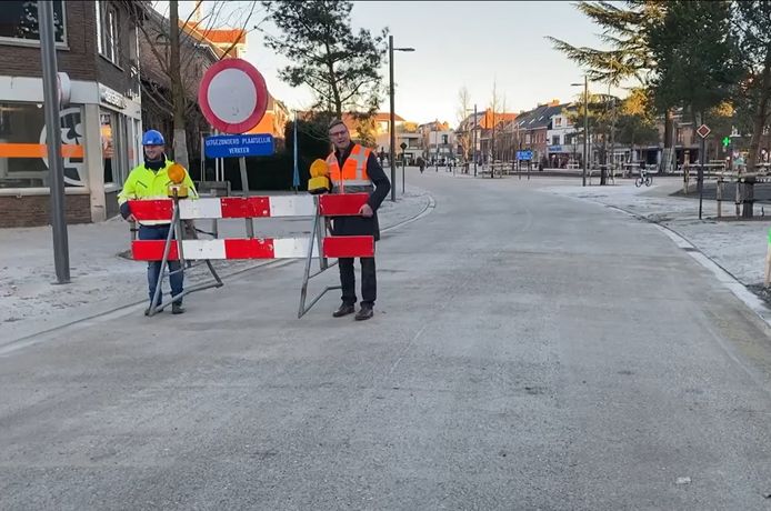 Burgemeester Ward Kennes (rechts) neemt de laatste signalisatie mee weg