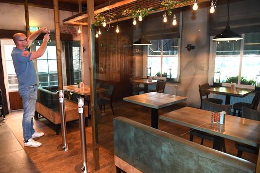 Eigenaar Pim van Beurden is bezig met het bevestigen van een scheidingswand in grand-café De Zwaan.