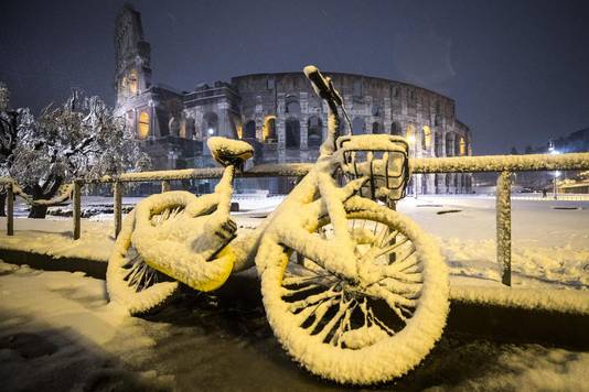 Een ondergesneeuwde fiets nabij het Colosseum in Rome, Italië.
