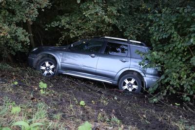 Auto raakt van weg en komt onderaan talud terecht in Waspik