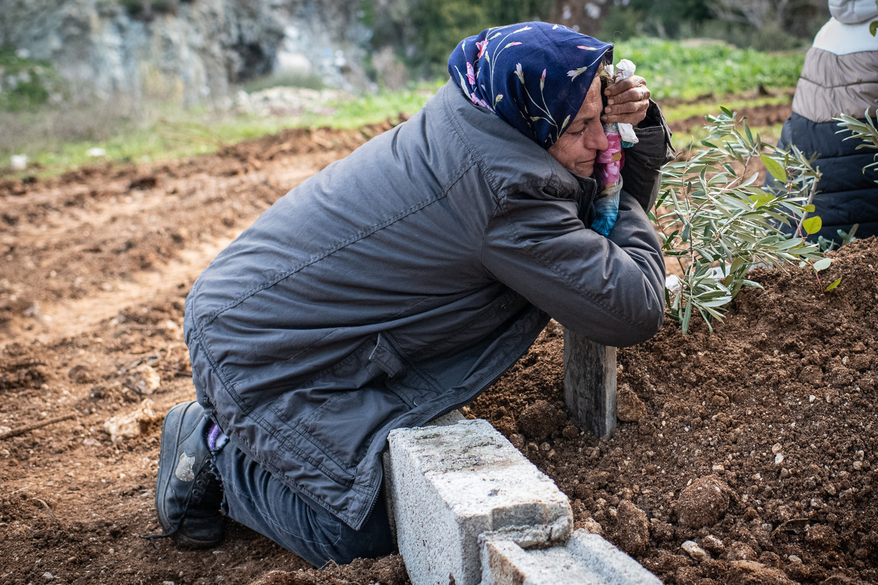 Een vrouw omhelst het graf van een familielid op een begraafplaats in Antakya.  Beeld NurPhoto via Getty Images