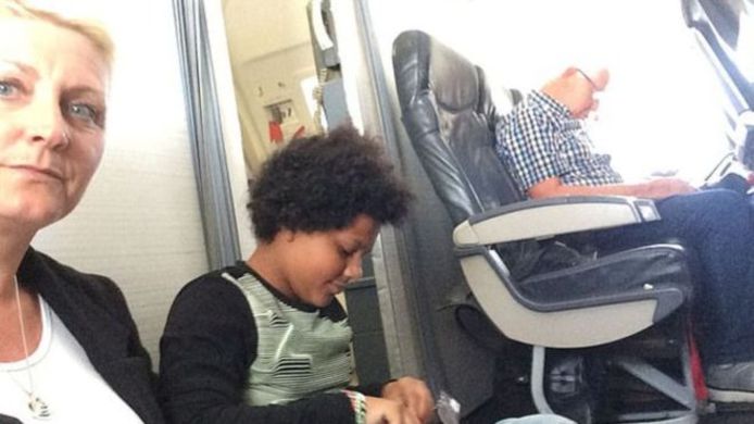 Paula Taylor met haar dochter Brooke, zittend op de vloer van het vliegtuig.