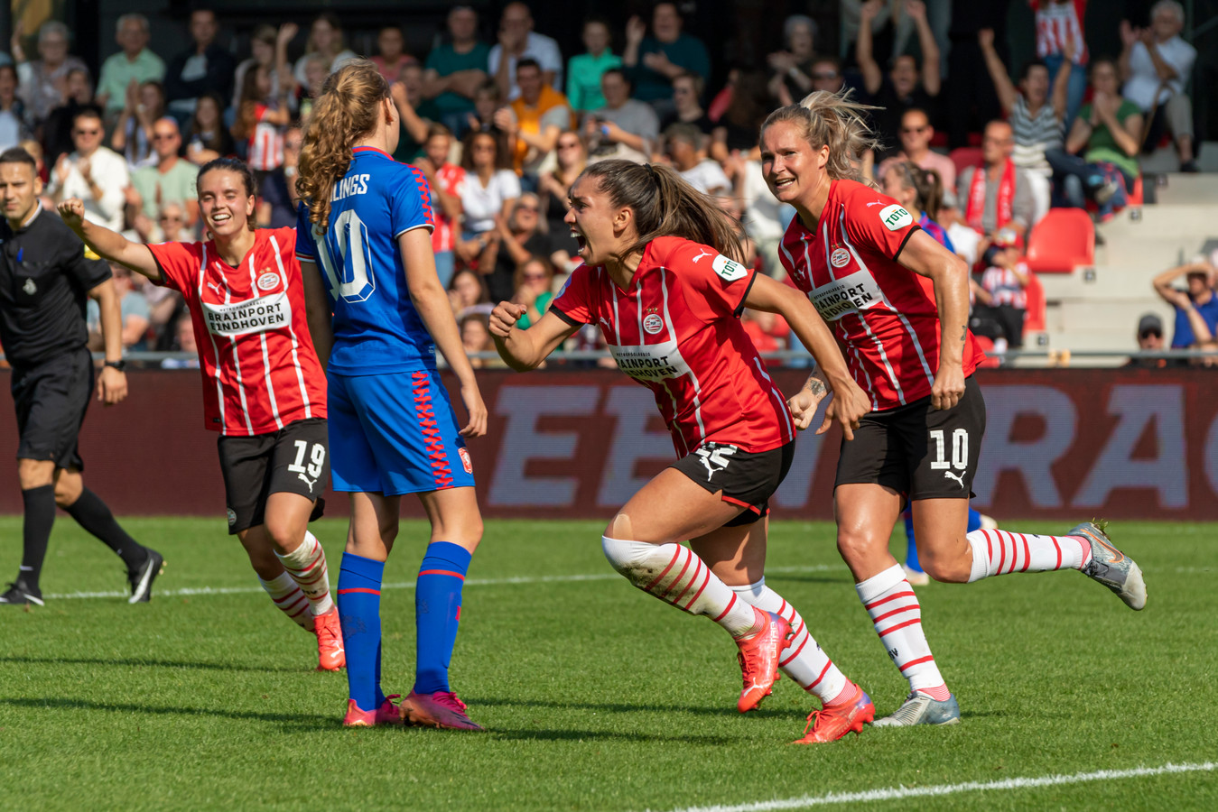 Anika Rodriguez schreeuwt het uit nadat ze PSV op voorsprong heeft gezet. Desiree van Lunteren (r) en Jeslynn Kuijpers (l) juichen mee.