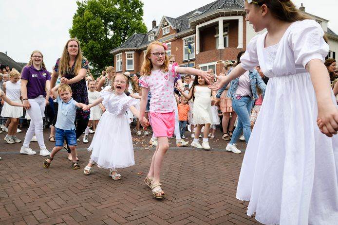 Twee jaar kon niet, maar dit jaar zongen en dansten de Pinksterbruidjes eindelijk weer in onder de kleurrijke Pinksterkroon op het Dorsetplein.