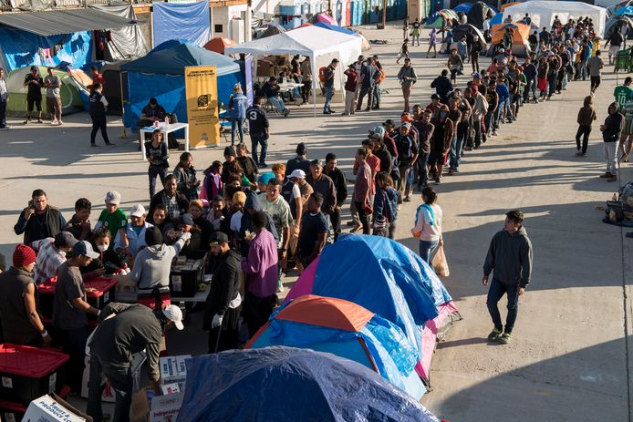 Vluchtelingen staan in de rij tijdens een voedselbedeling in Tijuana aan de Mexicaanse grens