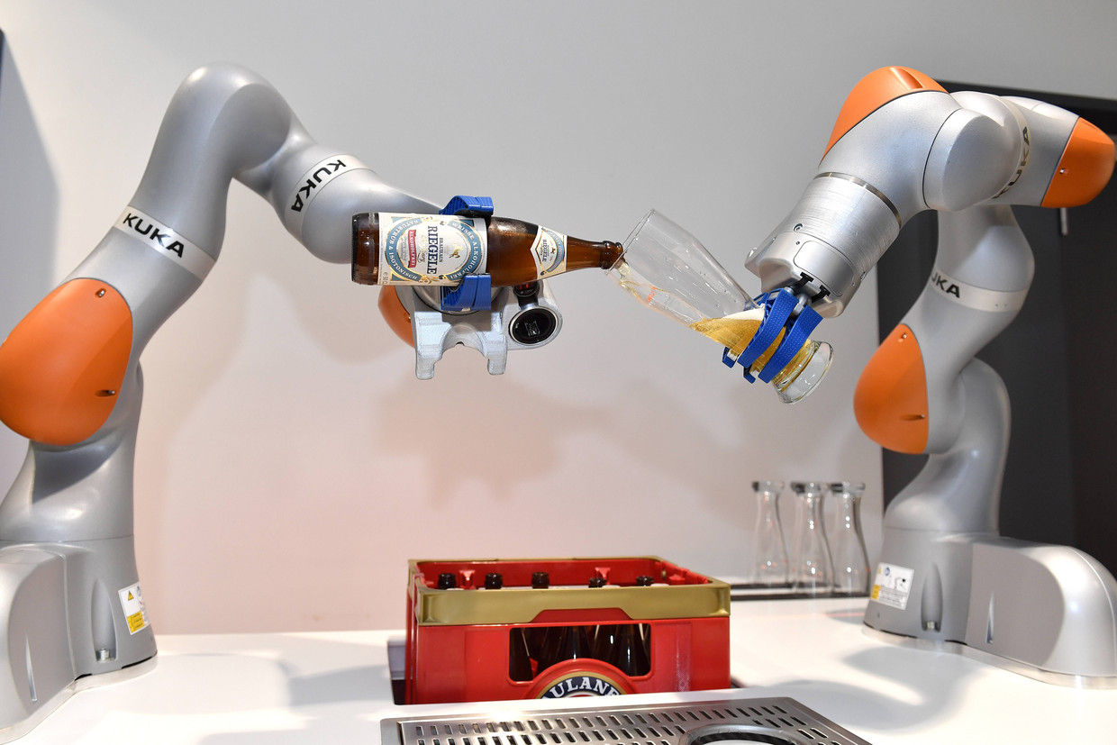 Robots van Kuka openen een bierflesje en schenken een glas in. Chinezen kochten vorig jaar de Duitse robotbouwer. Beeld Hollandse Hoogte / Imago Stock & People GmbH