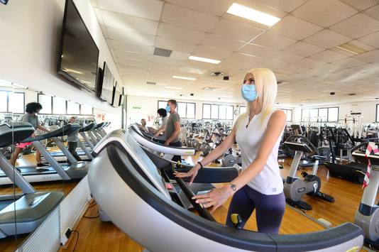 Fitnesscentra in Italië zoals hier in Bologna zijn sinds maandag opnieuw geopend. De meeste sporters dragen mondmaskers.