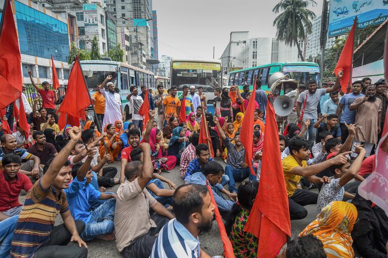 Bengaalse activisten houden een zitactie. De naaiers willen dat Bangladesh een minimumloon invoert.  Beeld AFP