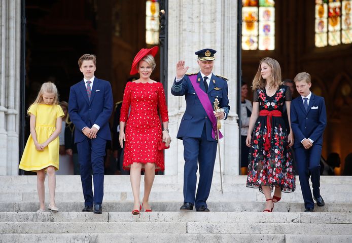 Prinses Eléonore in het geel, koningin Mathilde in het rood en kroonprinses Elisabeth in het zwart, groeten de royalfans na afloop van het Te Deum.  De prinsen Gabriël en Emmanuel (rechts) gingen strak in het pak naar de plechtigheid.