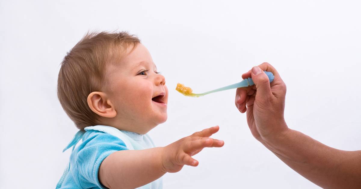 Onthaalmoeder die paplepel te diep in mond van zes maanden oude baby steekt voor rechter