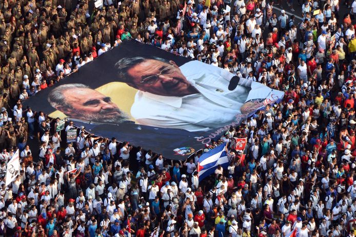 Een doek met een foto van de broers Fidel en Raúl Castro wordt bij de 1-meiviering in 2017 door de straten van de Cubaanse hoofdstad Havana gedragen.