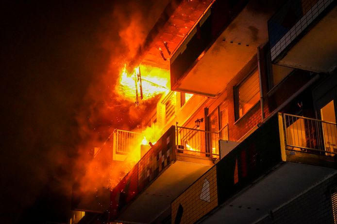 De vlammen slaan uit de woning naar buiten en zijn overgeslagen naar naastgelegen appartementen.