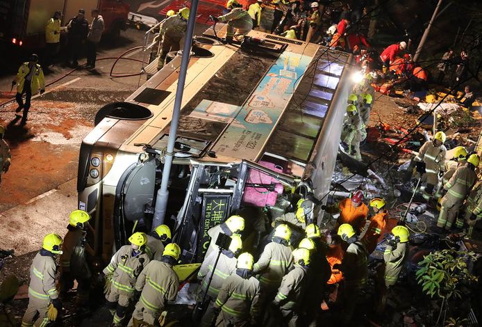 Bij een busongeluk met een dubbeldeksbus in Hongkong zijn zeker negentien doden en veertig gewonden gevallen. Door nog onbekende oorzaak kwam de dubbeldekker op z'n kant terecht. Foto SCMP