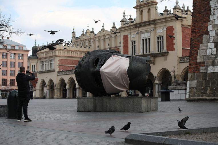 Een bekend standbeeld in de Poolse stad Krakow kreeg een mondmasker aangemeten. Beeld via REUTERS