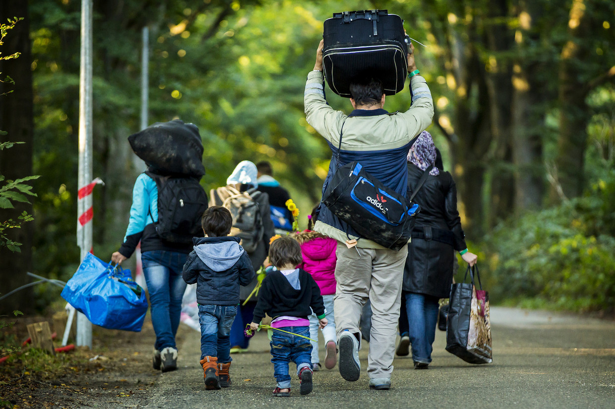 Een kleine groep vluchtelingen verlaat de noodopvang Heumensoord. Beeld anp