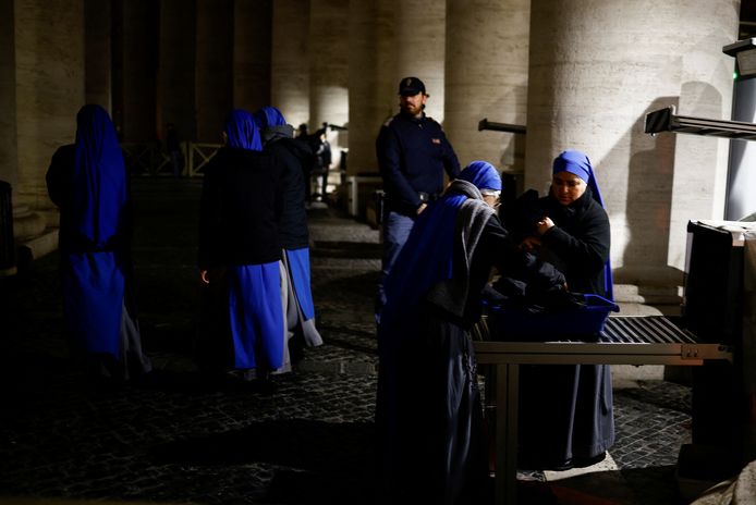 Enkele nonnen gaan in de vroege uurtjes door de beveiligingscontrole.