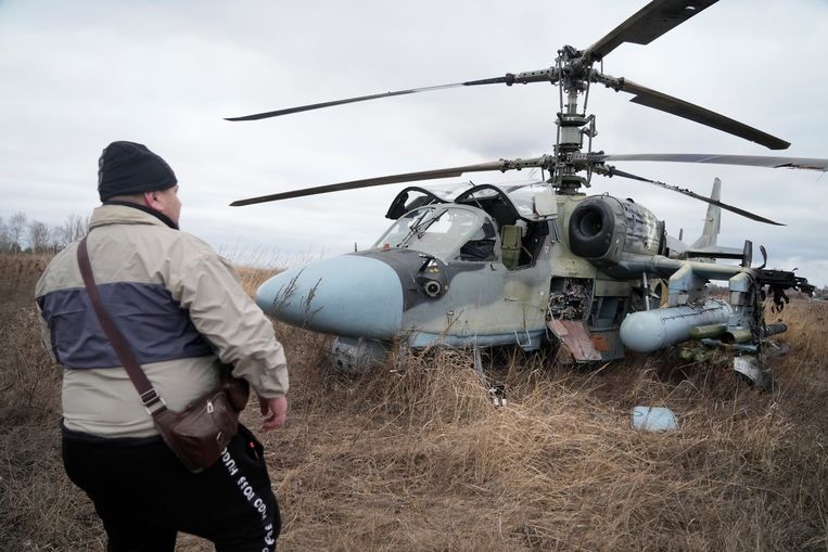 Un uomo si trova vicino a un elicottero russo Ka-52 che avrebbe dovuto atterrare vicino alla capitale ucraina, Kiev.  L'aeroporto di Kiev è stato teatro di pesanti combattimenti per tutta la mattina e ora si dice che sia stato preso.  immagine AP