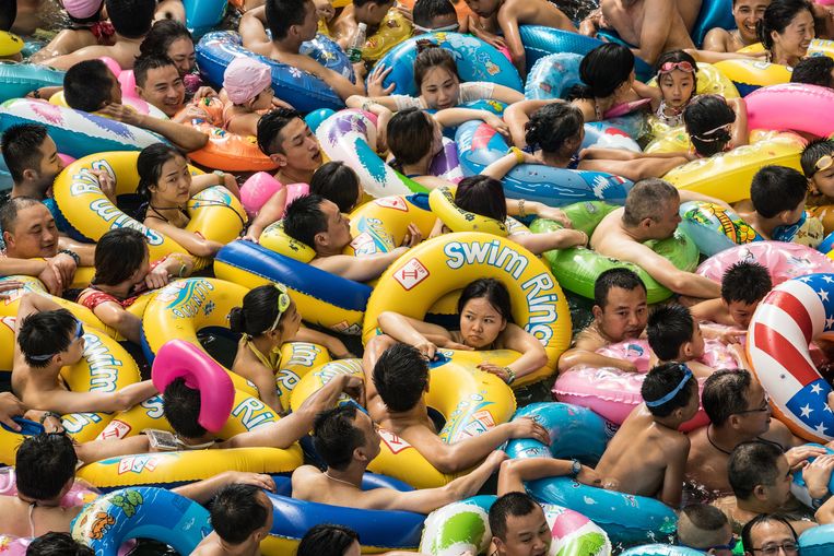 Een druk zwempartijtje in een meer in de Chinese provincie Sichuan. Chinees onderzoek ging na hoe het klimaat onze persoonlijkheid beïnvloedt, en wat de gevolgen zijn als de wereldwijde temperatuur stijgt. Beeld EPA