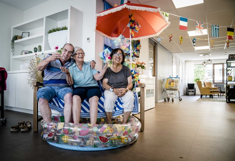 Bewoners van een verzorgingshuis in Zoetermeer zitten ter verkoeling met hun voeten in een zwembadje. Beeld ANP / Bart Maat