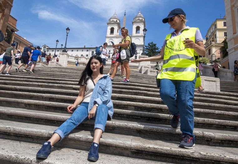 Een agent vraagt een toerist om niet op de Spaanse Trappen te zitten. Beeld EPA