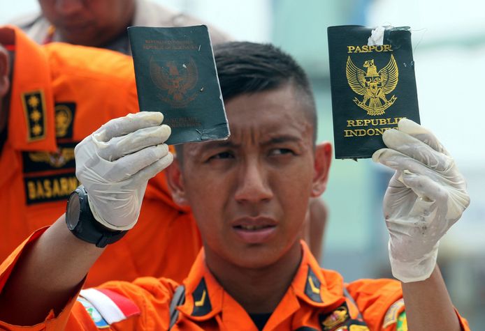 Reddingwerkers tonen gevonden voorwerpen, waaronder paspoorten van passagiers van vlucht JT61-0