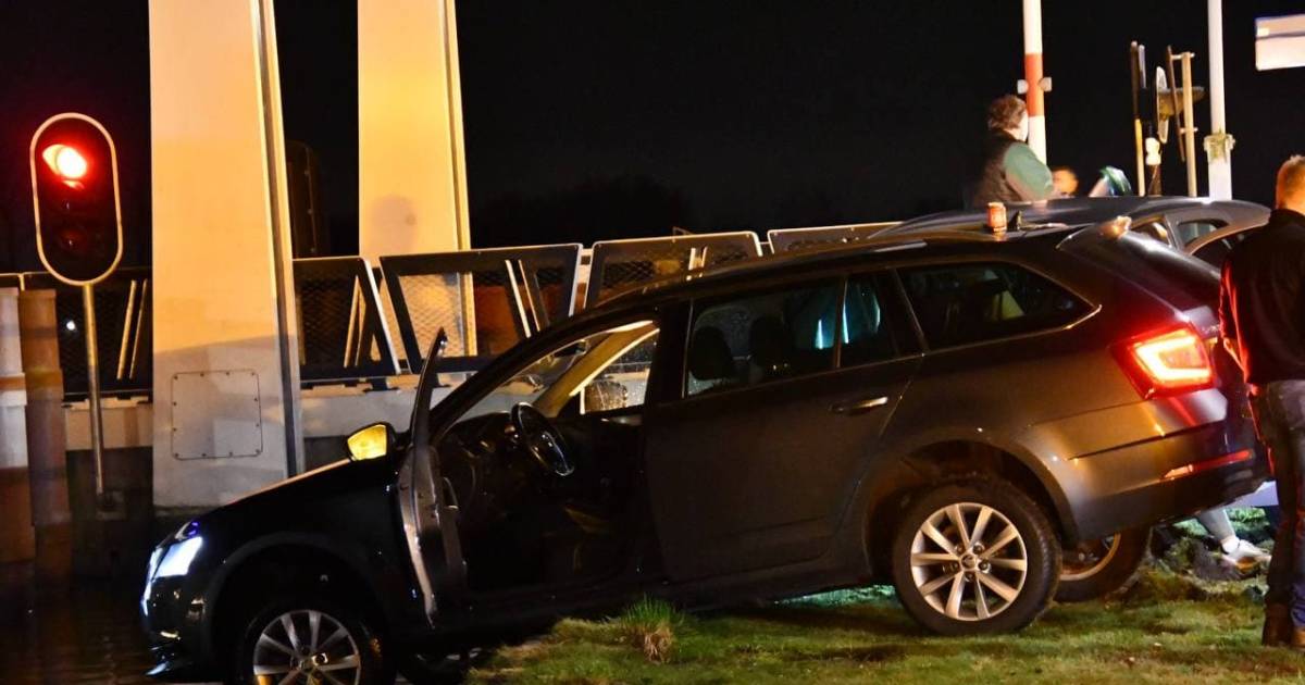 Oeps, deze auto bungelt na een botsing wel heel gevaarlijk boven het kanaal in Beerzerveld!.