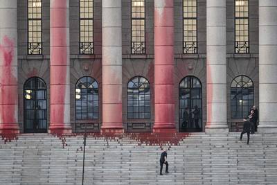 Climate activists deface Finnish parliament with red paint