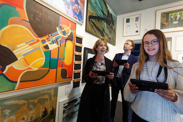 Kunstenaar Cecilia Vissers, wethouder Menno Roozendaal en kinderburgemeester Elin de Baaij lopen de kunstroute, mét tablet.