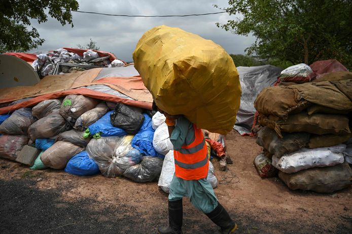 In this picture taken on July 16, 2019, a municipal worker carries a bag of recycling items at a site in Islamabad. - From the once pristine rivers of Hindu Kush to the slums of Islamabad, Pakistan is being smothered by plastic due to a lack of public awareness, government inertia, and poor waste management. (Photo by AAMIR QURESHI / AFP) / TO GO WITH Pakistan-environment-plastic,FEATURE by Joris Fioriti