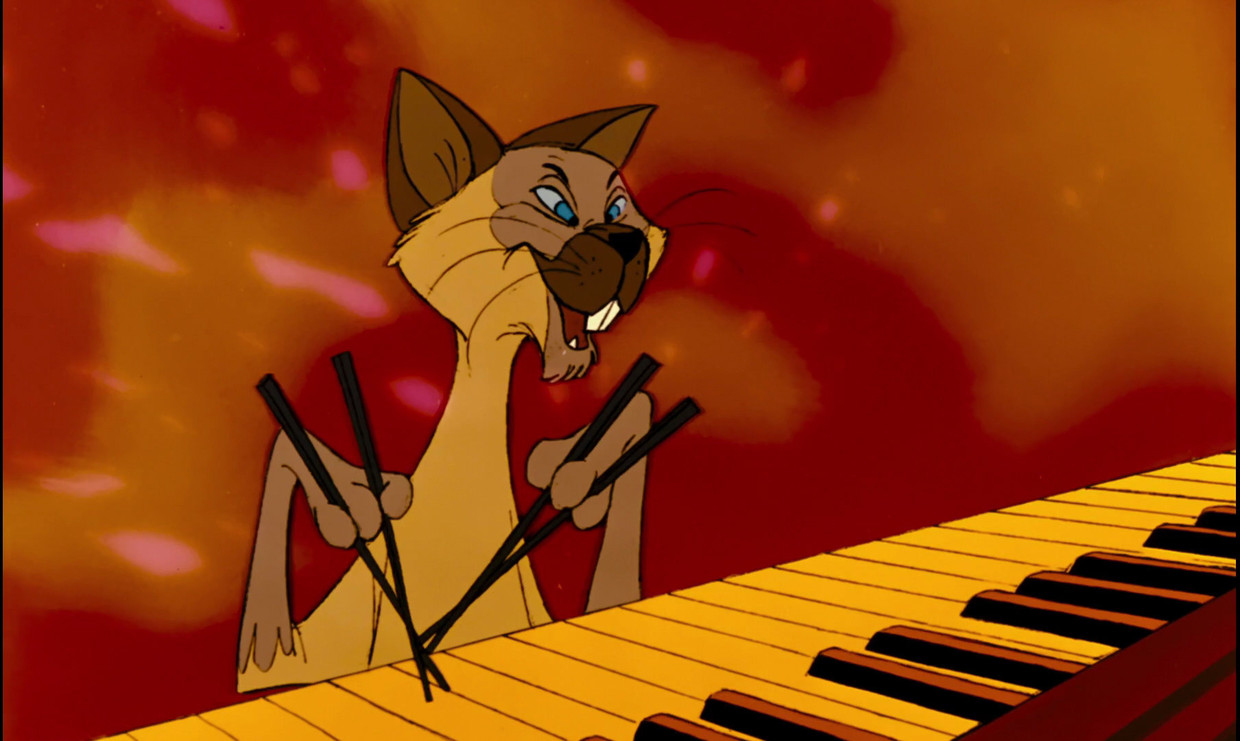 in ‘The Aristocats’ zingt een Siamese kat met een raar Aziatisch accent en bespeelt het dier de piano met eetstokjes.  Beeld  