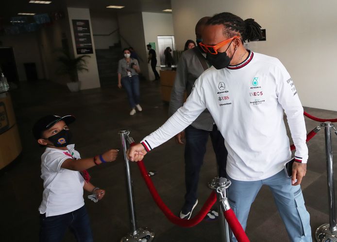 Lewis Hamilton begroet een jonge fan.
