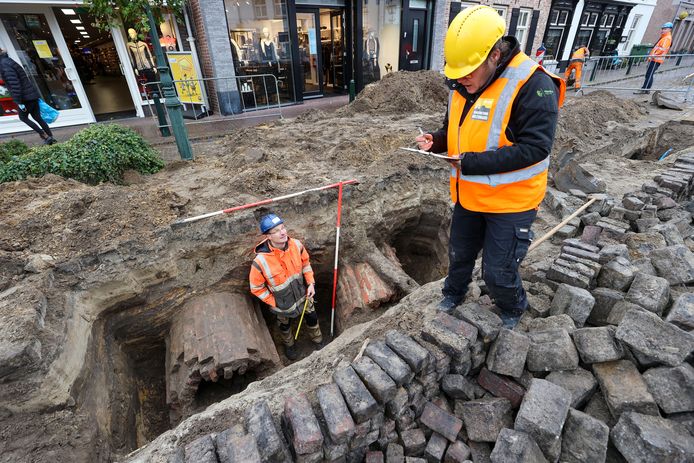 Martijn Bink en zijn partner Janneke Bosman (beiden archeologen, maar zij is in dienst van de Omgevingsdienst Zuidoost-Brabant) maken notities en schetsen bij de twee vermoedelijk honderd jaar oude rioleringsbuizen in de Rijkesluisstraat in Oirschot.