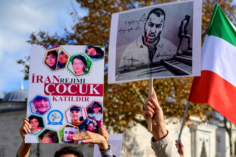 Op een rally in Istanbul houden betogers een portret van Toomaj Salehi omhoog, net als de gezichten van kinderen en jongeren die stierven tijdens de Iraanse protesten. Beeld AFP