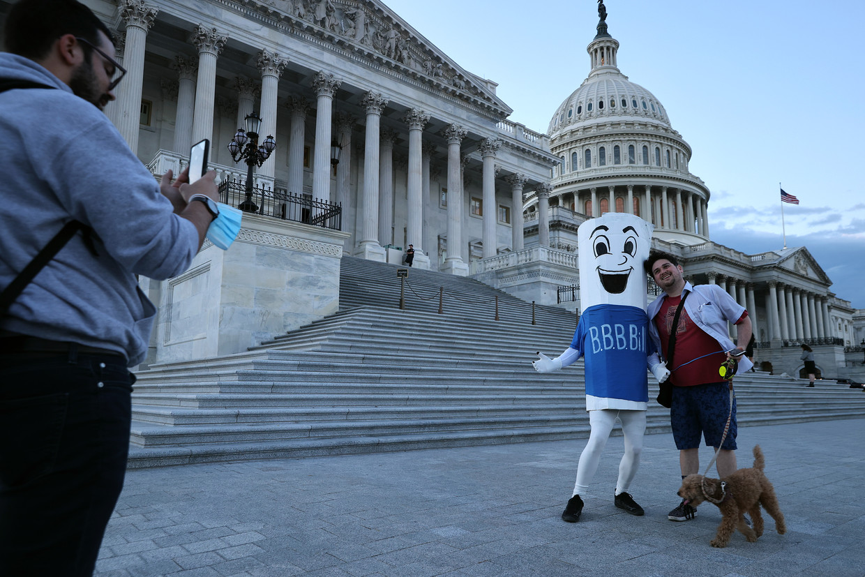 Verkleed in een BBB-kostuum poseert vakbondsman Bob Hayes met passanten bij het Capitool in Washington. Beeld Getty Images