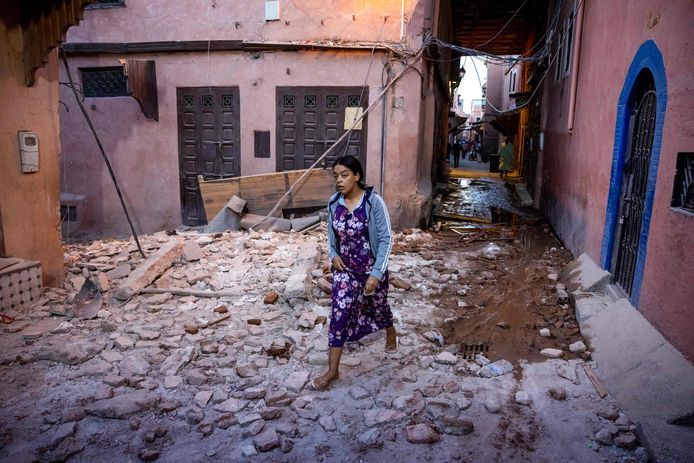 Een vrouw loopt door de puinhopen langs huizen die door een aardbeving zijn beschadigd in de oude stad in Marrakesh.