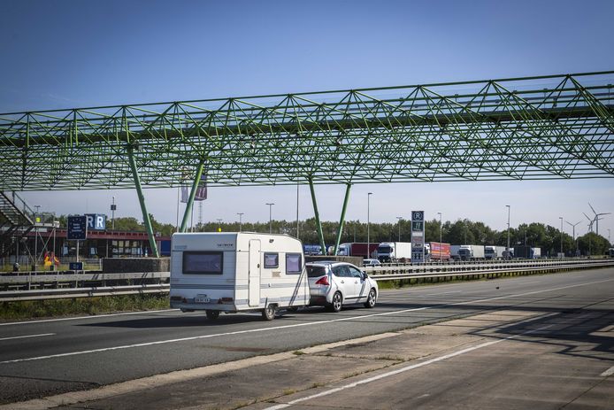 Vakantiegangers passeren de grens bij De Lutte.