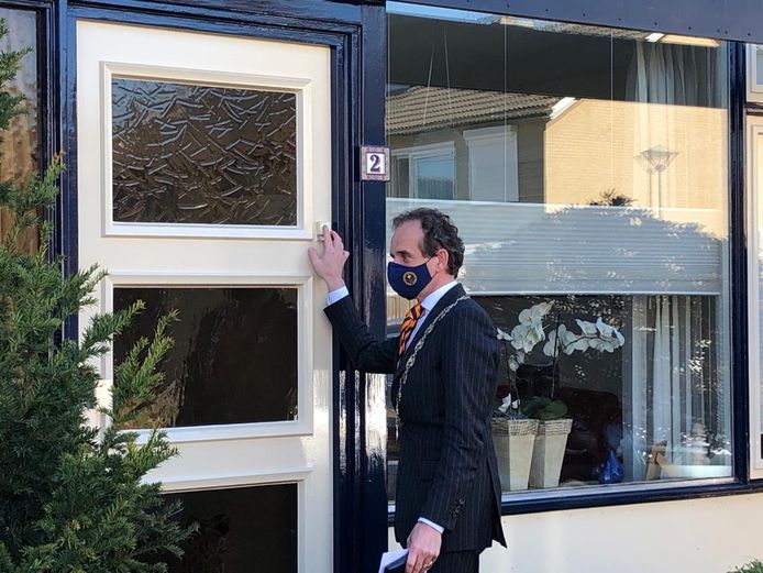 Burgemeester Slinkman belt aan om een lintje af te geven.