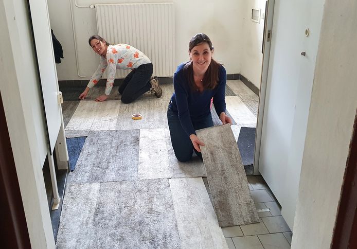 Vrijwilligers Annemarie te Maarssen (rechts) en Martine van Winckel leggen tapijttegels.