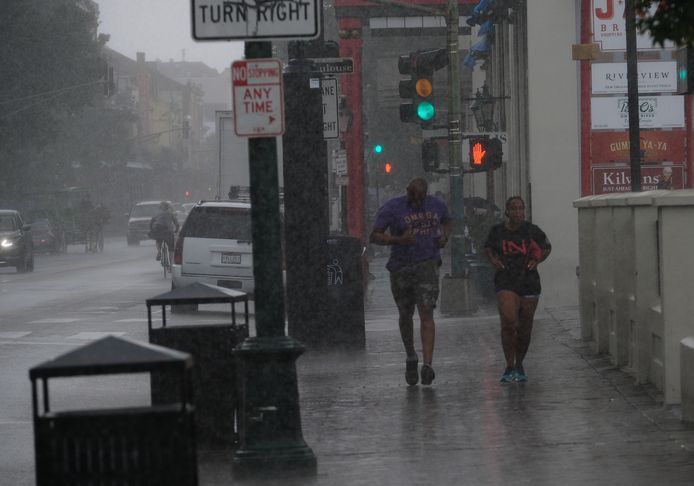 Inwoners rennen door de regen in de eerste tekenen van de storm.