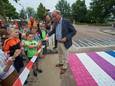 Ferre Otjens knipt het lint door om het regenboogzebrapad, dat er op zijn initiatief kwam, officieel te openen.