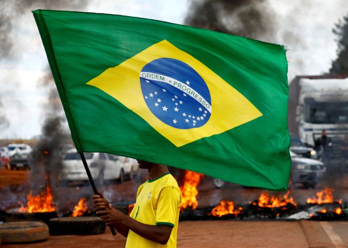 Een aanhanger van Bolsonaro met een Braziliaanse vlag doet mee aan een wegblokkade bij Planaltina. (31/10/22)