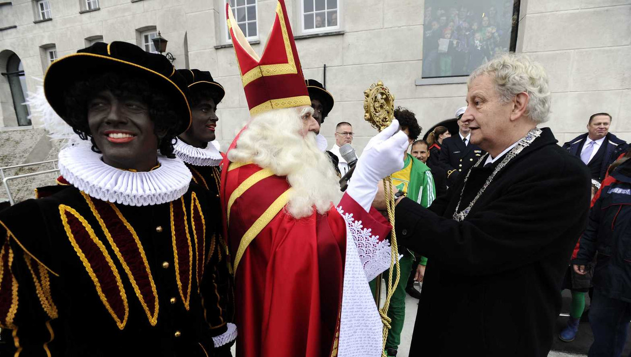Burgemeester Eberhard van der Laan (R) verwelkomt Sinterklaas en zijn pieten bij de intocht in Amsterdam, vorig jaar december. Beeld anp