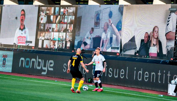 In Denemarken wordt wel al gevoetbald, naast het veld staan schermen waarop fans via een livestream thuis de match volgen.