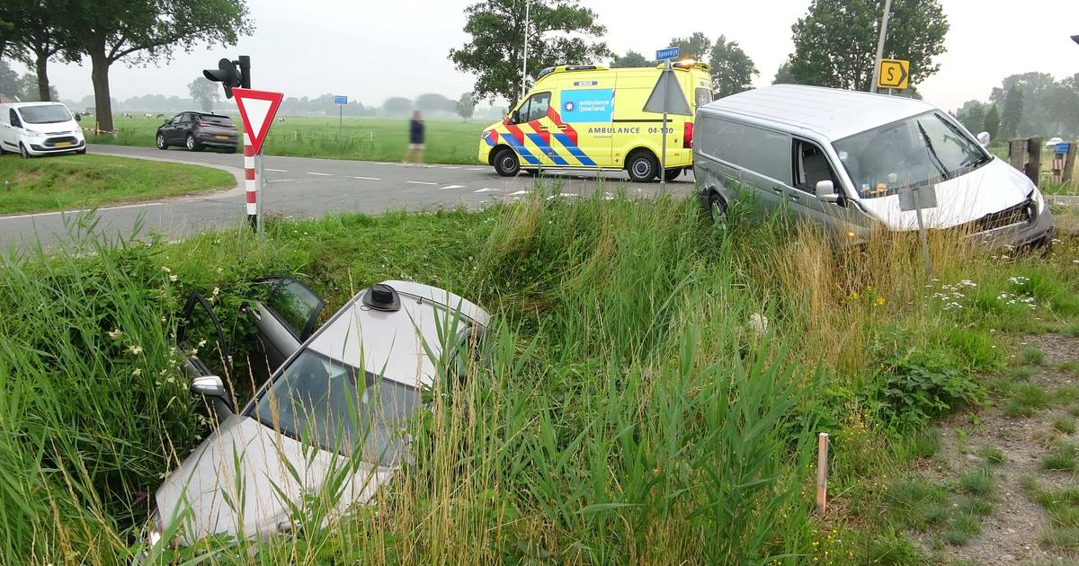 Auto eindigt in sloot na botsing met busje bij spoorwegovergang Staphorst: twee gewonden.