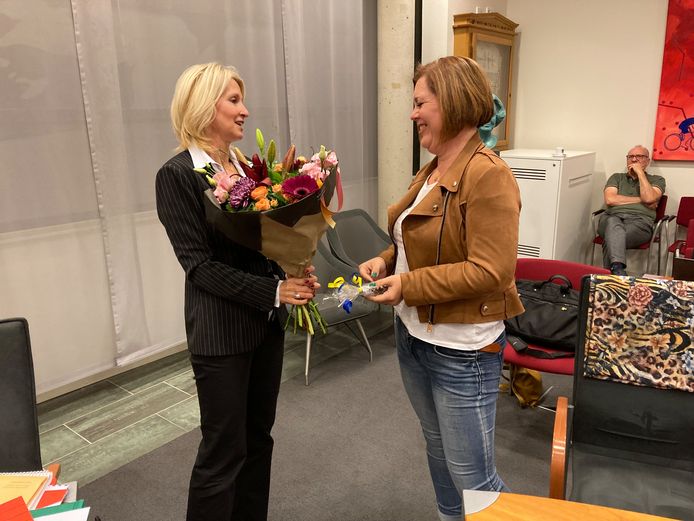 Burgermeester Caroline van den Elsen bedankt scheidend raadslid Nicole Dijcks (r) met een boeket bloemen